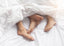 couples_feet_showing_from_under_bed_covers